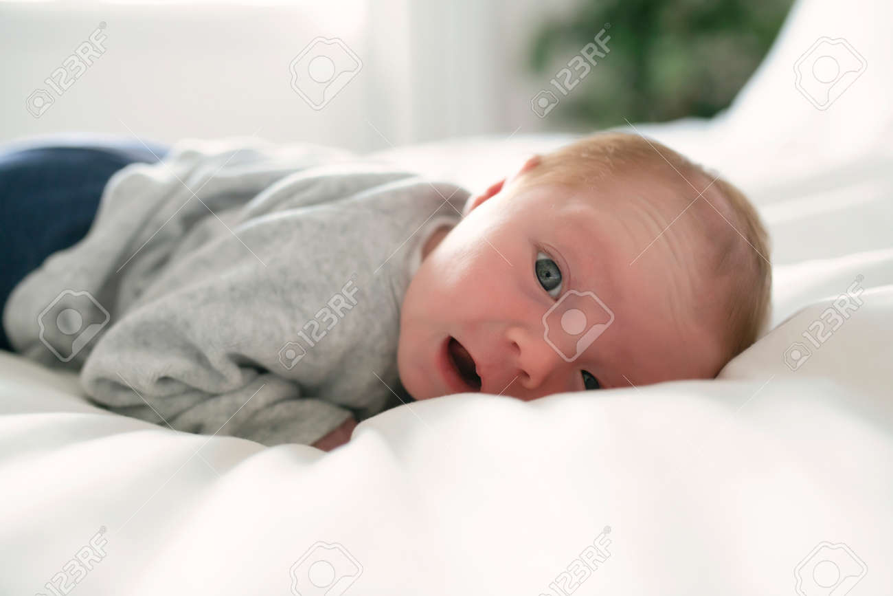 Cute newborn baby girl on the white bed - 157613339 Cute newborn baby girl on the white bed - 157613339