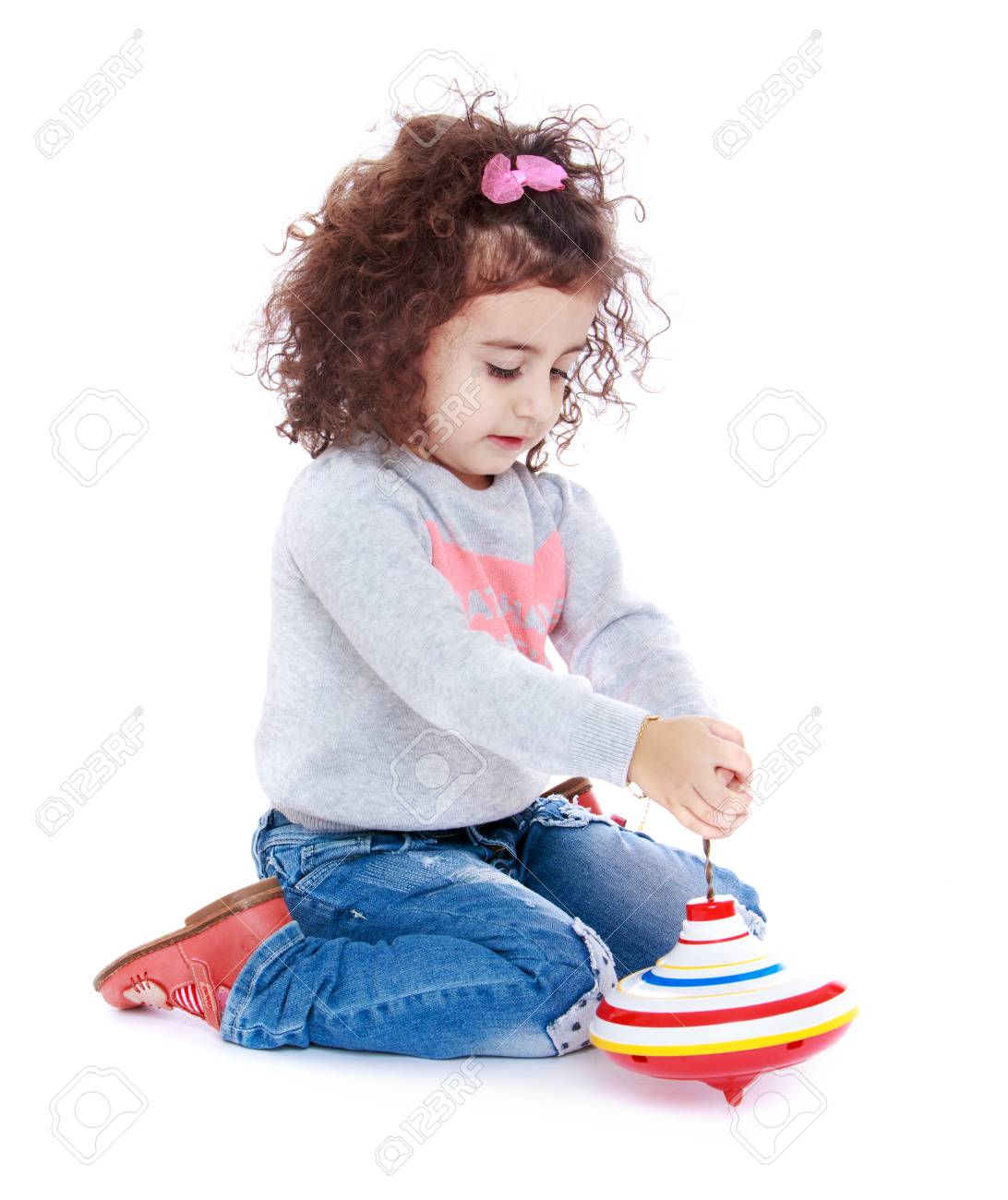 Cheerful Little Girl With Curly Hair Sitting On The Lap Top And