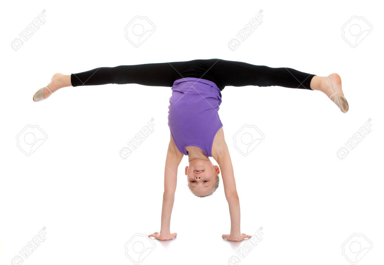 Slim pretty young girl athlete with hair combed into a ball is on your hands and do the splits. - 42931021 Slim pretty young girl athlete with hair combed into a ball is on your hands and do the splits. - 42931021