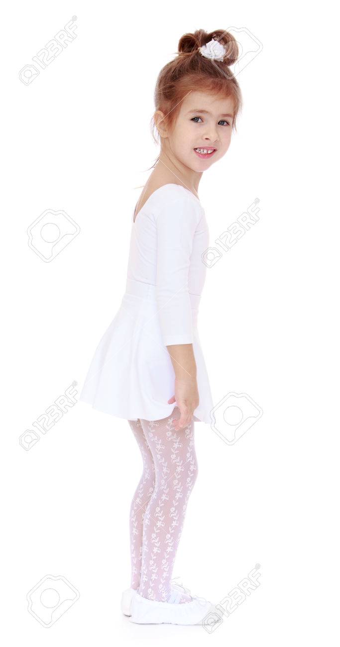 Cute Little Girl In A White Sports Leotard And White Stockings Stands Sideways To The Camera Cute Little Girl In A White Sports Leotard And White Stockings Stands Sideways To The Camera