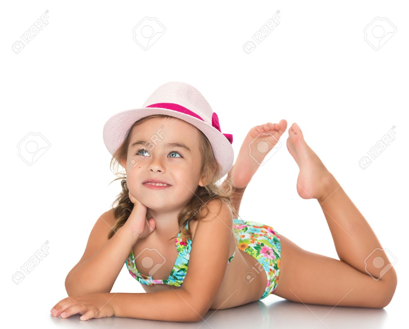 Adorable little girl in a pink hat and a bathing suit lying on the floor and looks up - Isolated on white background - 53604586 Adorable little girl in a pink hat and a bathing suit lying on the floor and looks up - Isolated on white background - 53604586