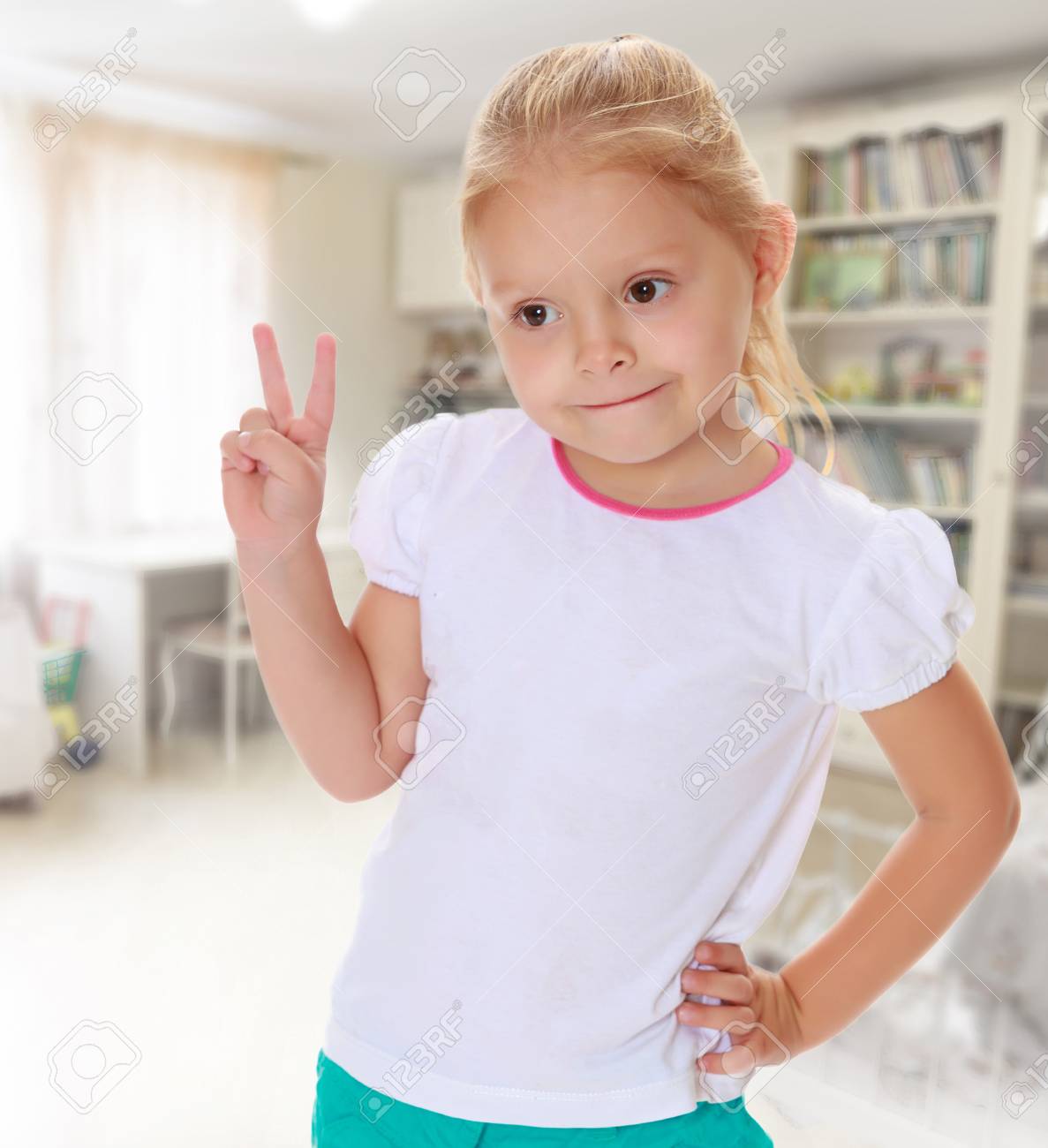 家族の幸せと本棚子供部屋に対して 子の就学前教育の概念 金髪でかわいい女の子白いタンクトップのパターンがないです 女の子は ビクトリアの兆候を示しています の写真素材 画像素材 Image