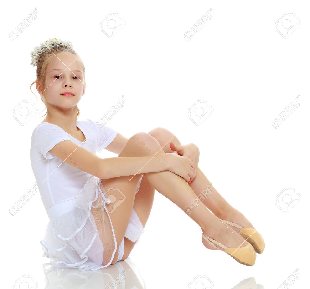 Girl gymnast posing sitting on the floor. - 75360861 Girl gymnast posing sitting on the floor. - 75360861