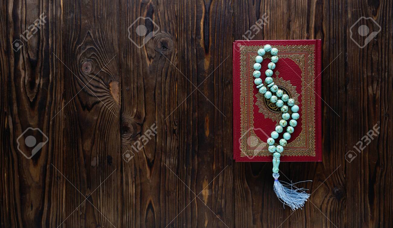 Islamic book Koran with rosary beads on wooden background. Islamic concept with copy space - 129083809 Islamic book Koran with rosary beads on wooden background. Islamic concept with copy space - 129083809
