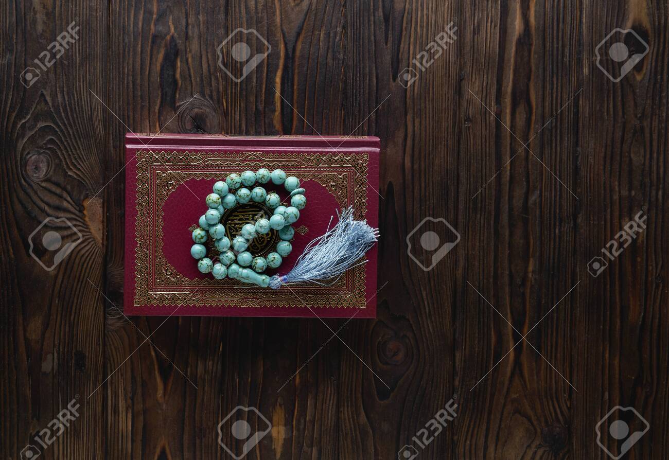 Islamic book Koran with rosary beads on wooden background. Islamic concept with copy space - 129083807 Islamic book Koran with rosary beads on wooden background. Islamic concept with copy space - 129083807
