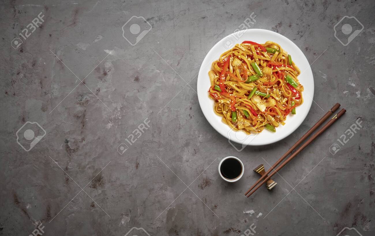 Chinese noodles with beef and vegetables on grey stone background .Top view, copy space - 129154738 Chinese noodles with beef and vegetables on grey stone background .Top view, copy space - 129154738