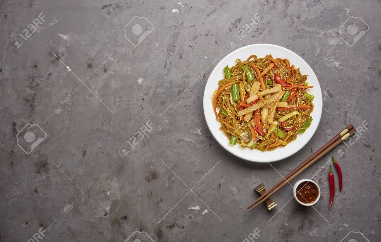 Chinese noodles with beef and vegetables on grey stone background .Top view, copy space - 129147200 Chinese noodles with beef and vegetables on grey stone background .Top view, copy space - 129147200