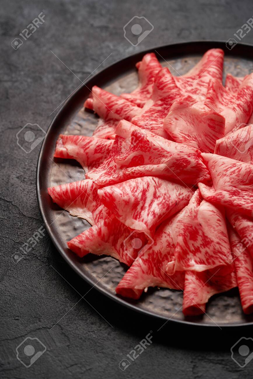 Japanese kobe beef sliced on ceramic plate on black background - 131905336 Japanese kobe beef sliced on ceramic plate on black background - 131905336
