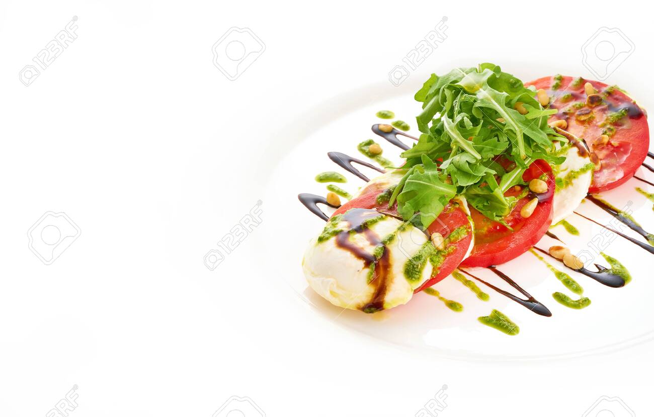 Salad with mozarella cheese, tomatoes, arugula and pesto sauce in white plate. - 131905180 Salad with mozarella cheese, tomatoes, arugula and pesto sauce in white plate. - 131905180