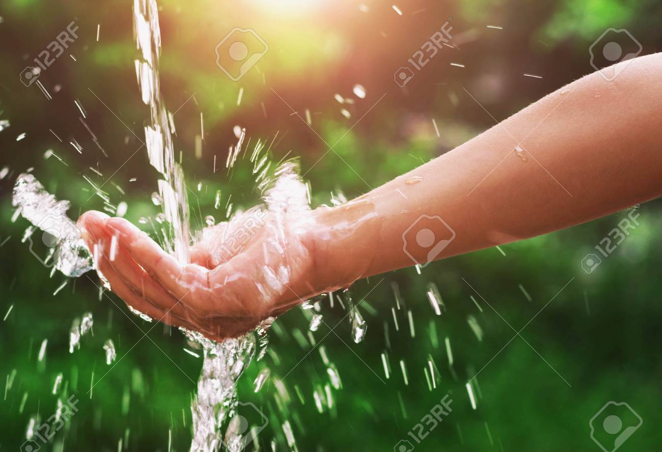 Water pouring splash in hand and nature background with sunshine - 80034076 Water pouring splash in hand and nature background with sunshine - 80034076