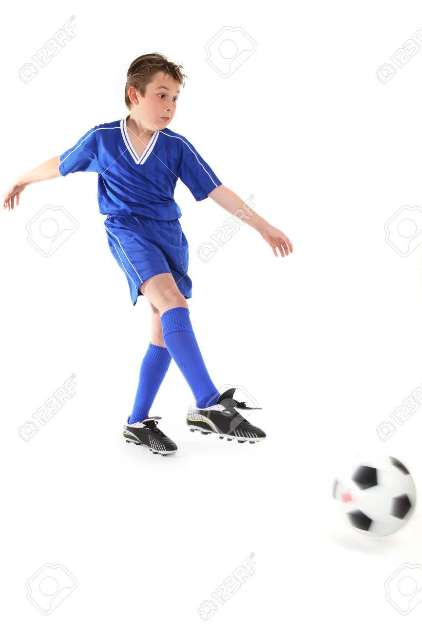 a boy kicks a soccer ball motion in ball and kicking leg stock