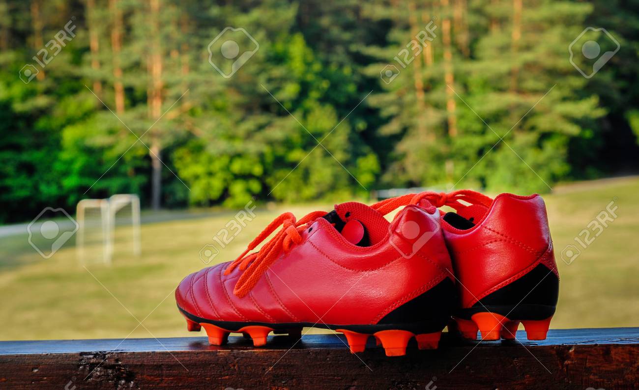 Red Soccer Shoes With Grass Field 