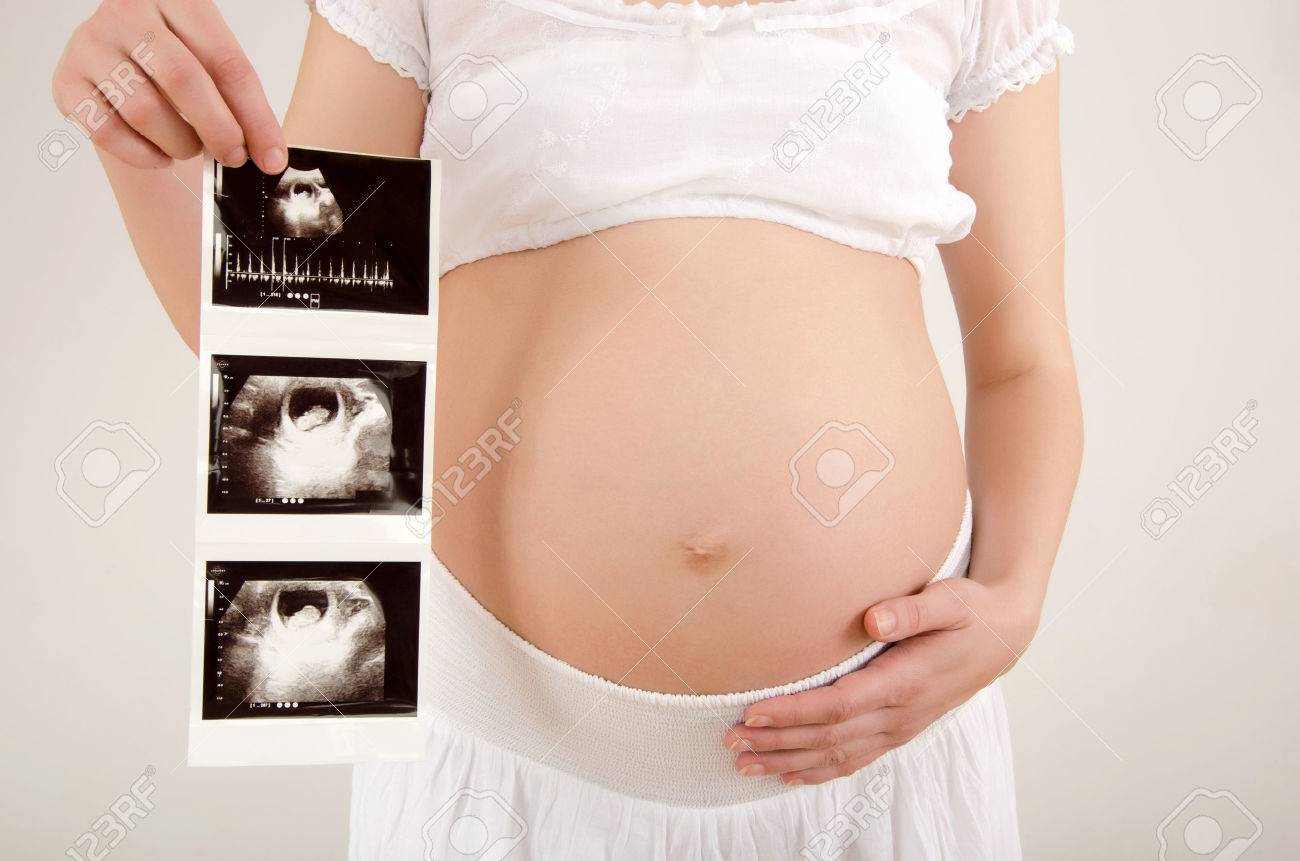 Gros Plan Sur Le Ventre De Femme Enceinte Avec L Echographie Du Bebe Femme Attend Un Bebe Vetu De Blanc Tenant L Echographie Du Bebe A Naitre Banque D Images Et Photos Libres De
