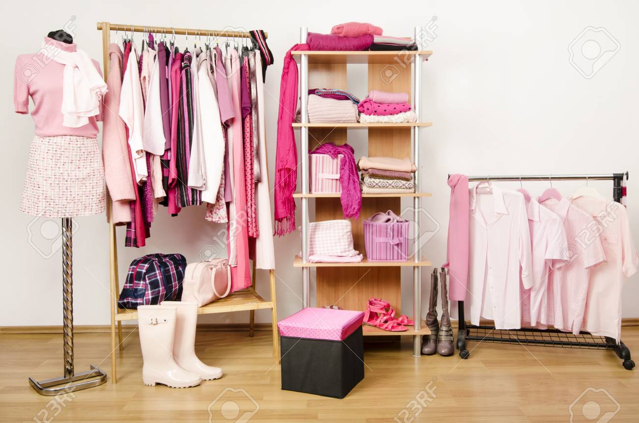 Dressing Closet With Pink Clothes Arranged On Hangers And Shelf
