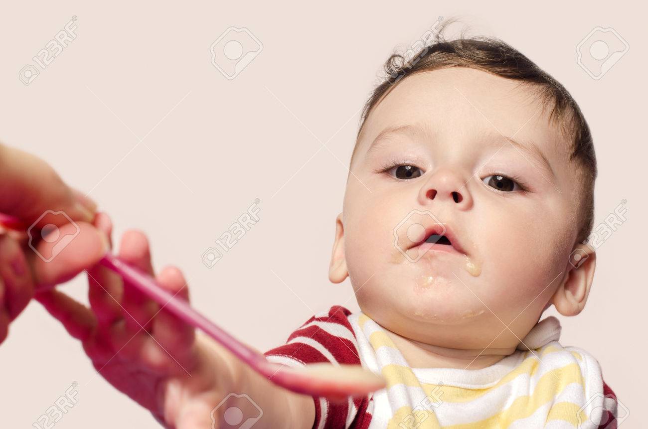 母の手は 乳児の離乳食を給餌 子供スプーンをつかむことを試みるします 6 ヶ月歳始まり食品の多様化 スプーンで食べ物を食べるかわいい男の子 の写真素材 画像素材 Image