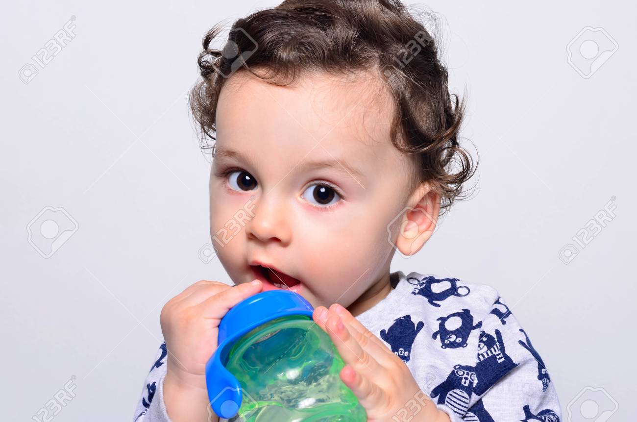 Portrait D Un Mignon Bambin L Eau Potable A La Bouteille Un Enfant Age D Un An Qui Joue Avec La Tasse De Bebe Adorable Garcon Aux Cheveux Boucles Ayant Soif Banque D Images Et Photos