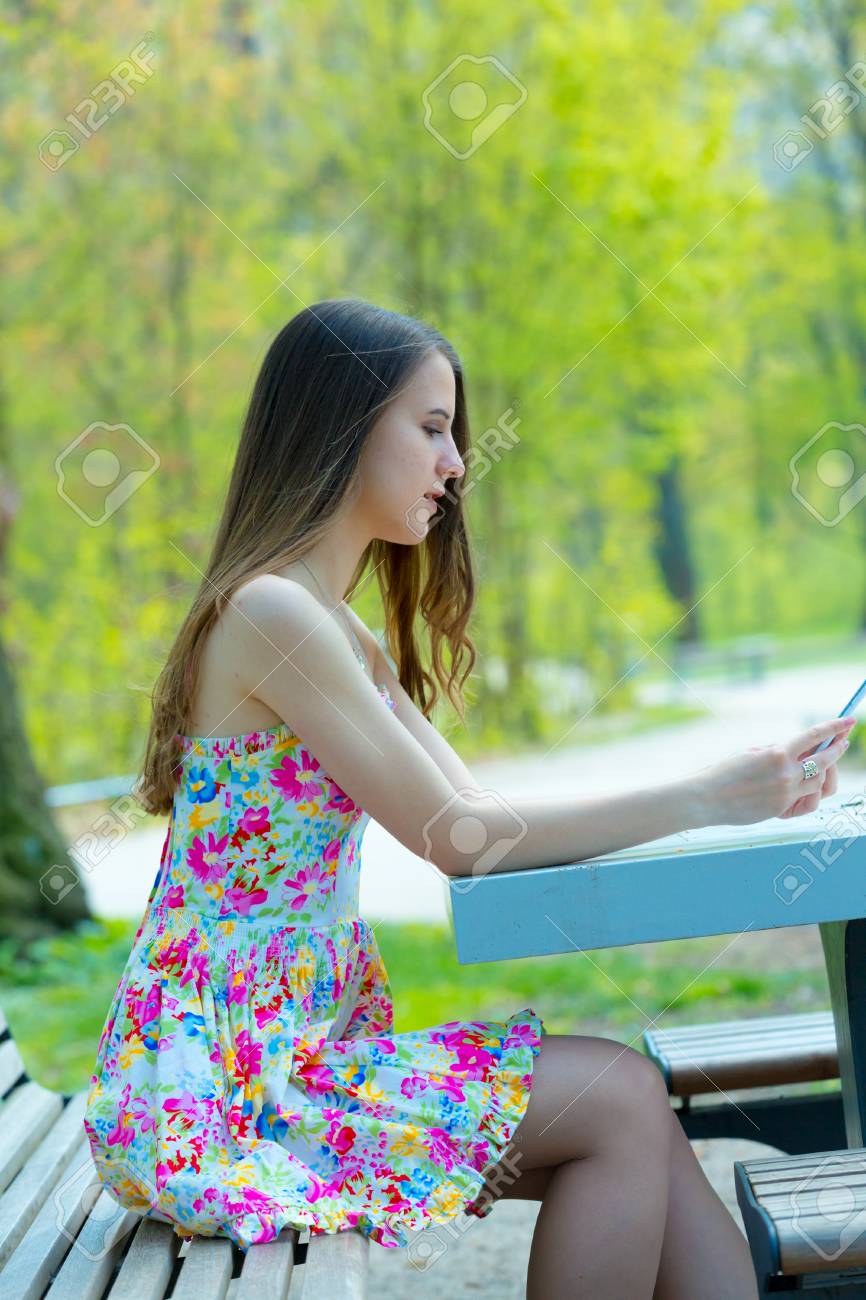 Portrait Of Young Beautiful Woman With Long Hair In Summer Park