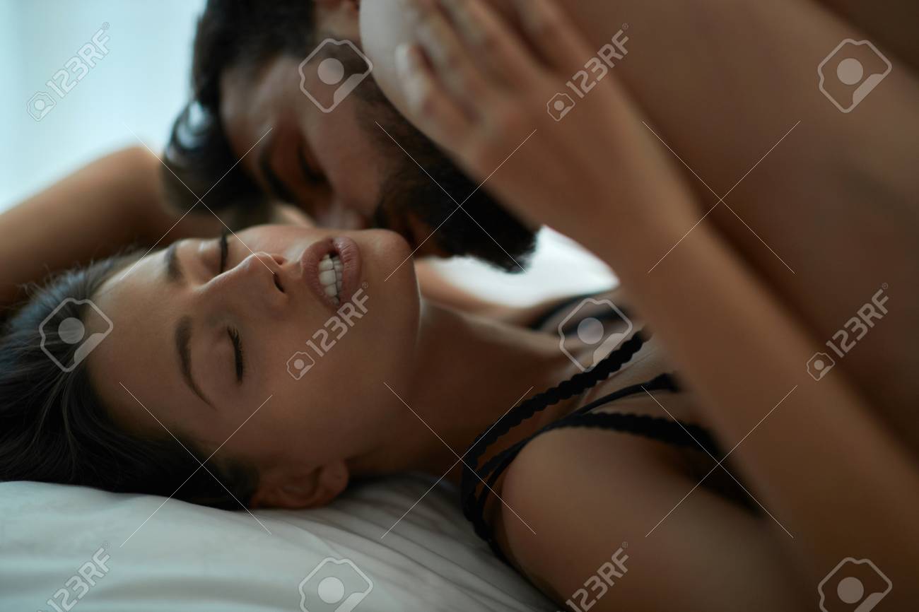 Young Couple Man And Woman Making Love Having Passionate Sex On Bed, Enjoying Pleasant Sensation, Stock Photo, Picture and Royalty Free Image