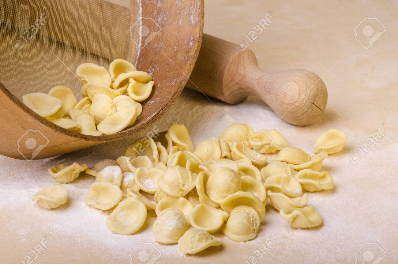 orecchiette, homemade pasta, freshly prepared, Italian regional recipe of Puglia on the table with rolling pin and sieve - 135538795 orecchiette, homemade pasta, freshly prepared, Italian regional recipe of Puglia on the table with rolling pin and sieve - 135538795