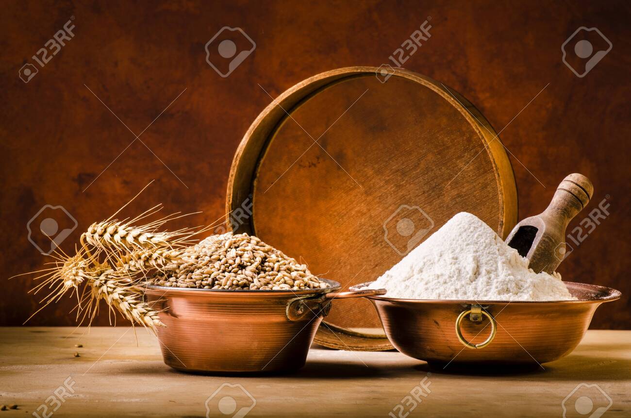 on the rustic wooden table some copper bowls with flour and wheat - 136915285 on the rustic wooden table some copper bowls with flour and wheat - 136915285