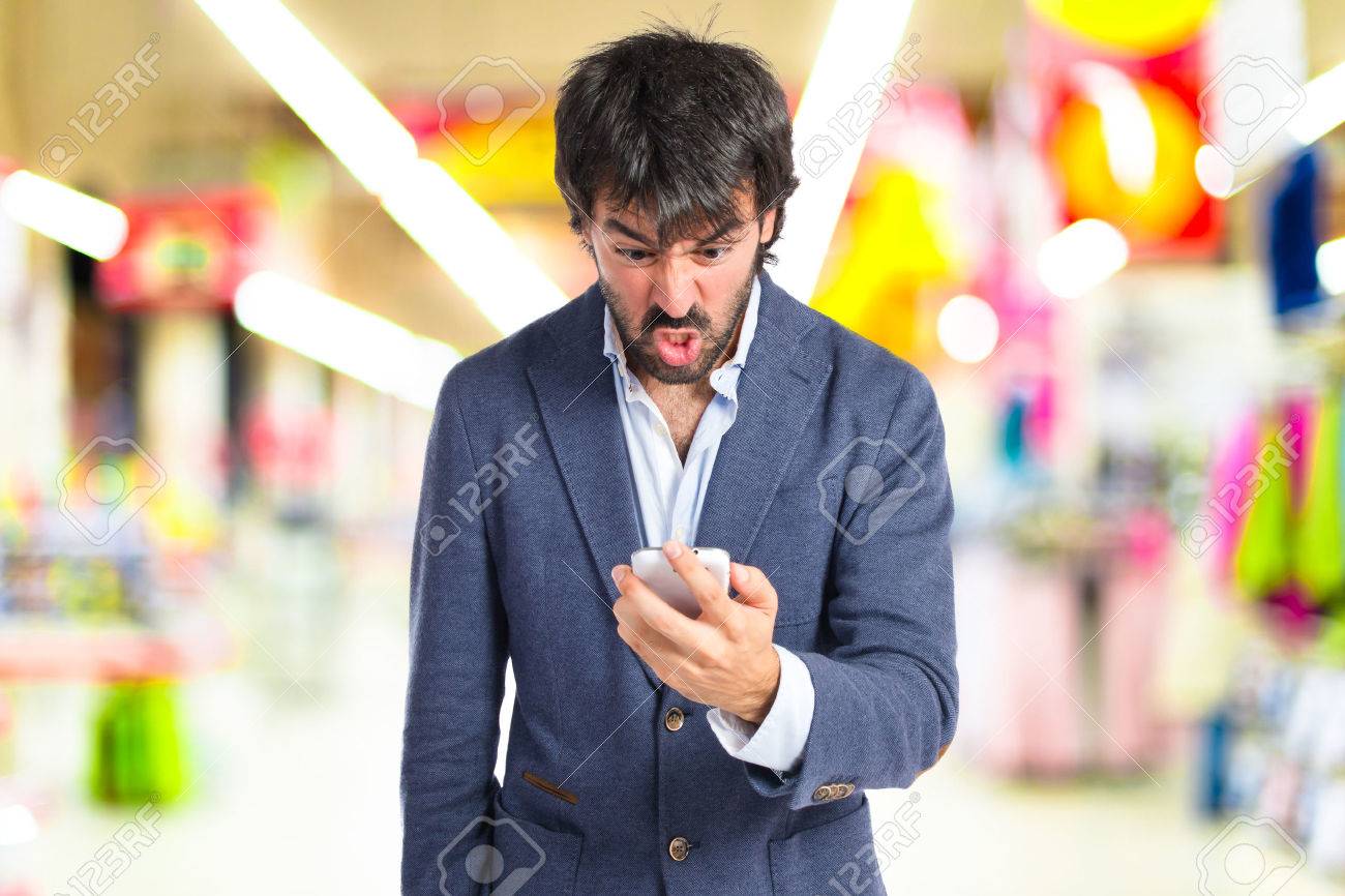 Angry man talking to mobile over white background - 43936576 Angry man talking to mobile over white background - 43936576