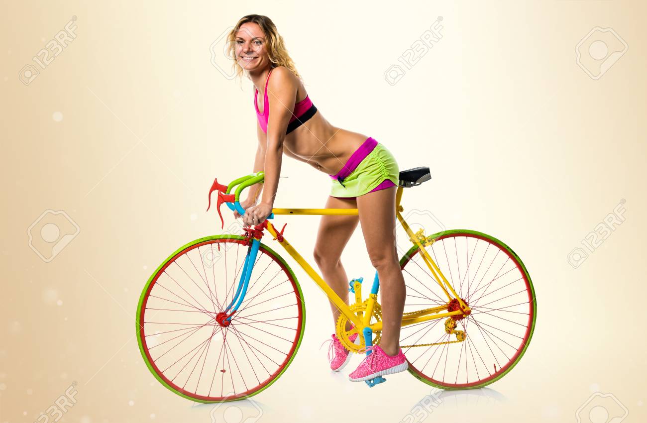 黄土色の背景にカラフルな自転車の金髪美女 の写真素材 画像素材 Image