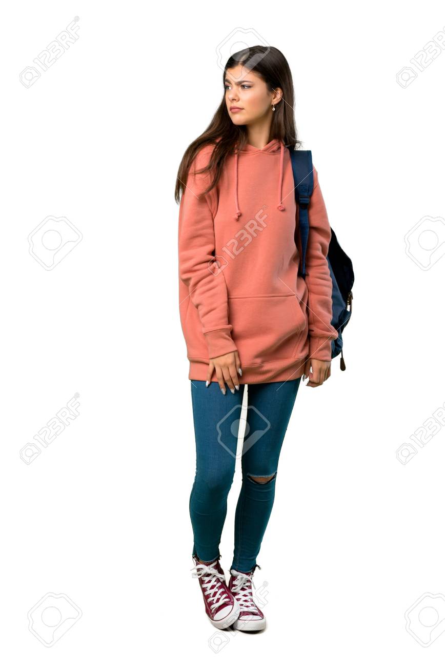 A full-length shot of a Teenager girl with sweatshirt and backpack feeling upset - 116494247 A full-length shot of a Teenager girl with sweatshirt and backpack feeling upset - 116494247