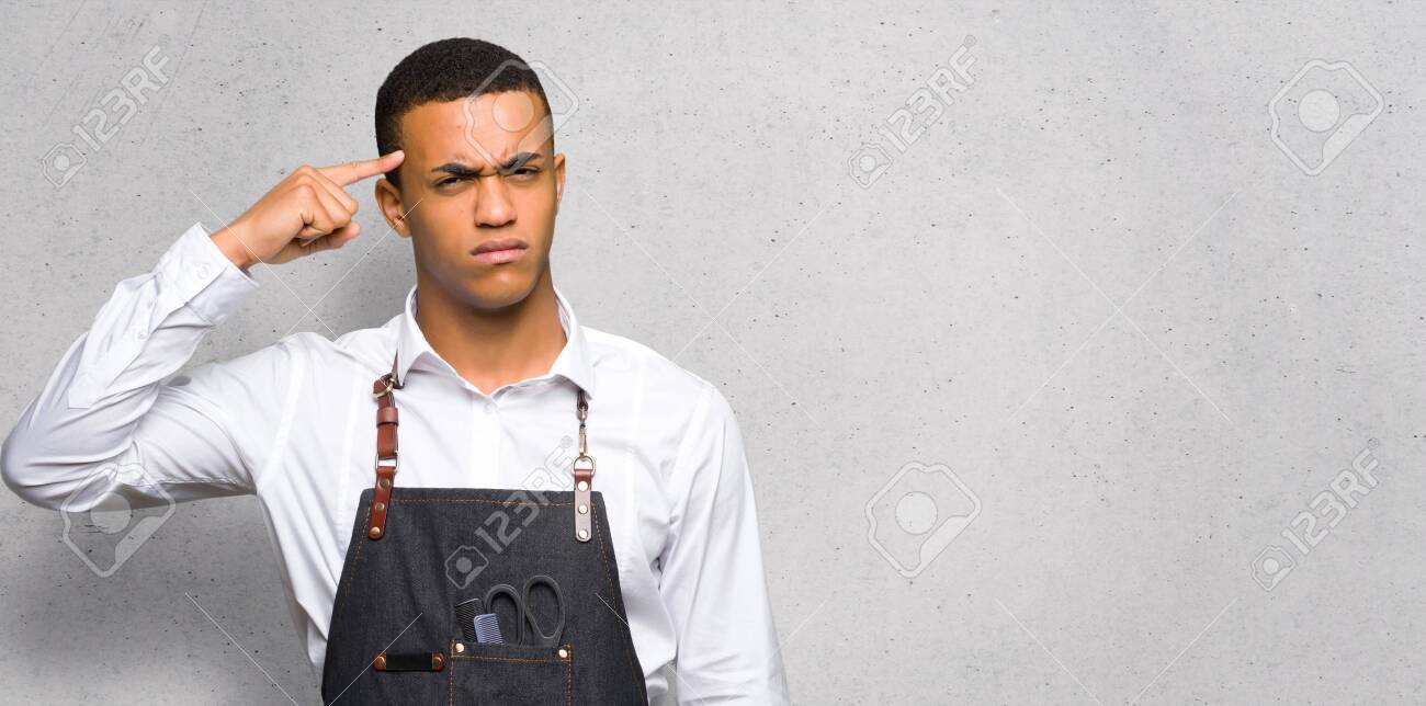Young afro american barber man making the gesture of madness putting finger on the head on textured wall - 120195624 Young afro american barber man making the gesture of madness putting finger on the head on textured wall - 120195624