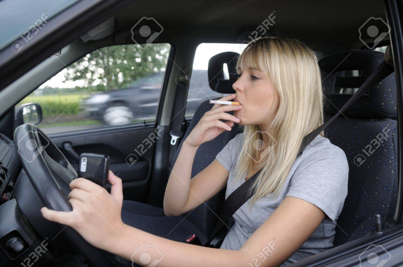 タバコと車の中で携帯電話を持つ若い女性 の写真素材 画像素材 Image