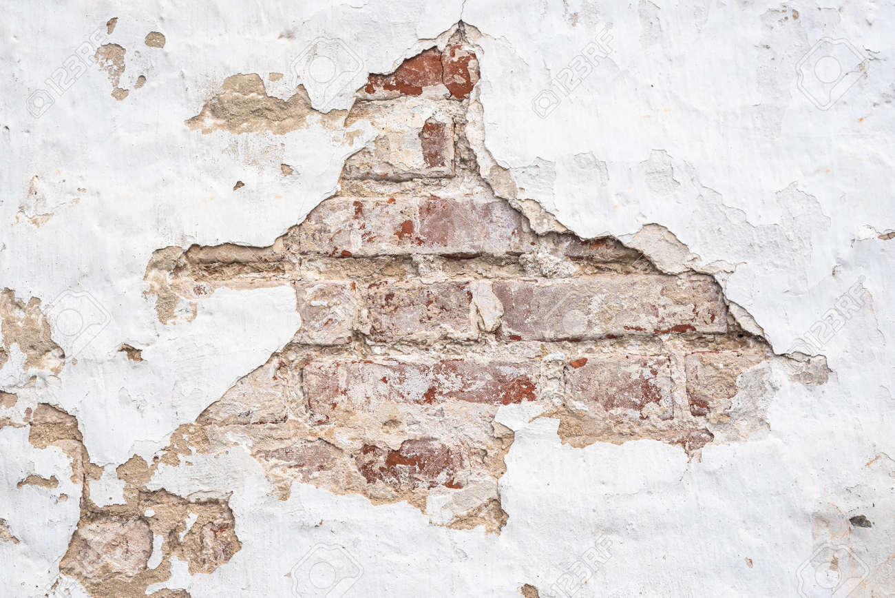 Wall of old building with large hole in chipped white stucco - 169328031 Wall of old building with large hole in chipped white stucco - 169328031