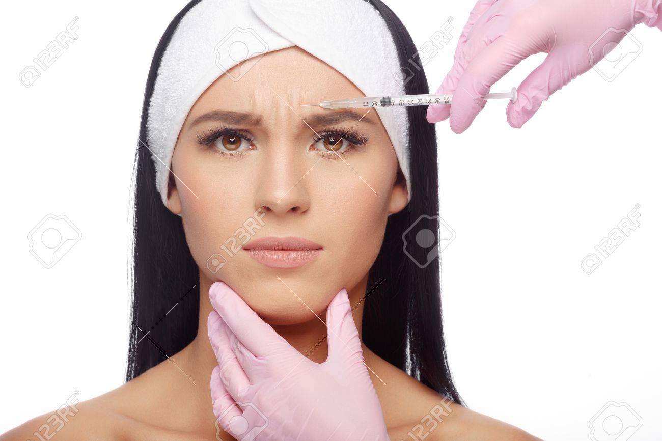 Beautiful woman getting lifting injection in forehead. Close-up woman hyaluronic acid injection. Injections of skin rejuvenation. Cosmetic procedures, injections, hyaluronic acid. - 63480265 Beautiful woman getting lifting injection in forehead. Close-up woman hyaluronic acid injection. Injections of skin rejuvenation. Cosmetic procedures, injections, hyaluronic acid. - 63480265