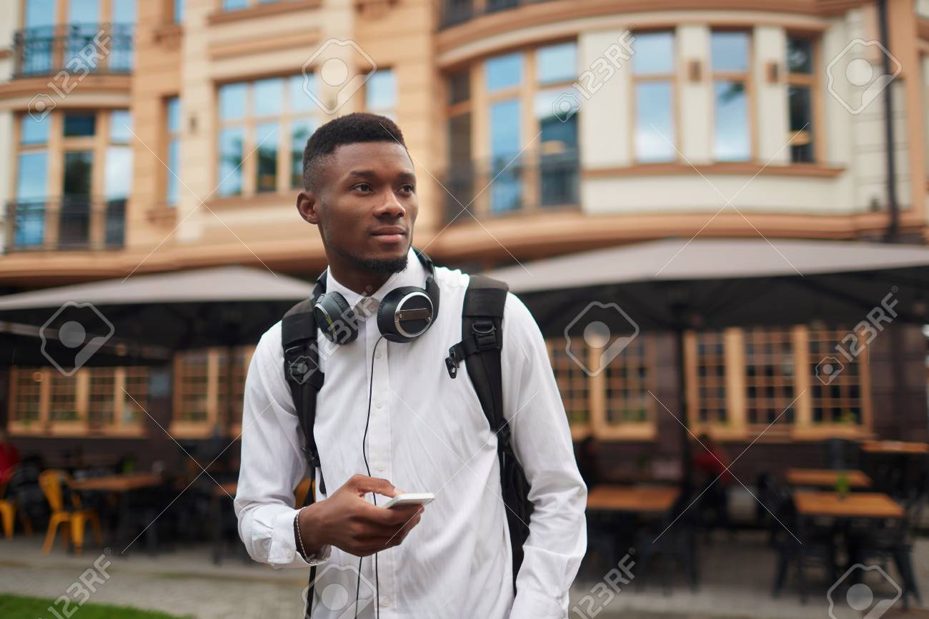 African male walking and searching location in smart phone. - 87555462 African male walking and searching location in smart phone. - 87555462
