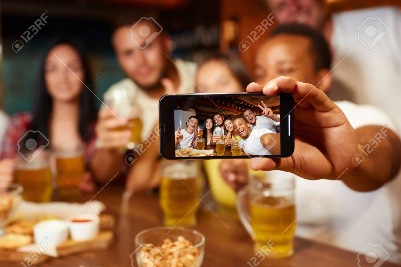 Group of funny friends taking self portrait in bar. - 107927695 Group of funny friends taking self portrait in bar. - 107927695