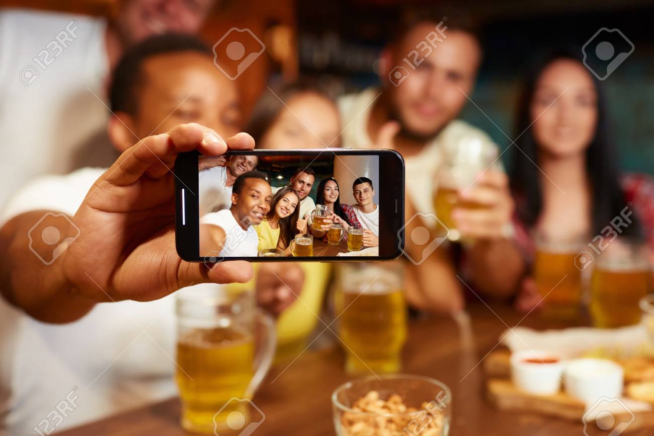 Group of funny friends taking self portrait in bar. - 107927735 Group of funny friends taking self portrait in bar. - 107927735