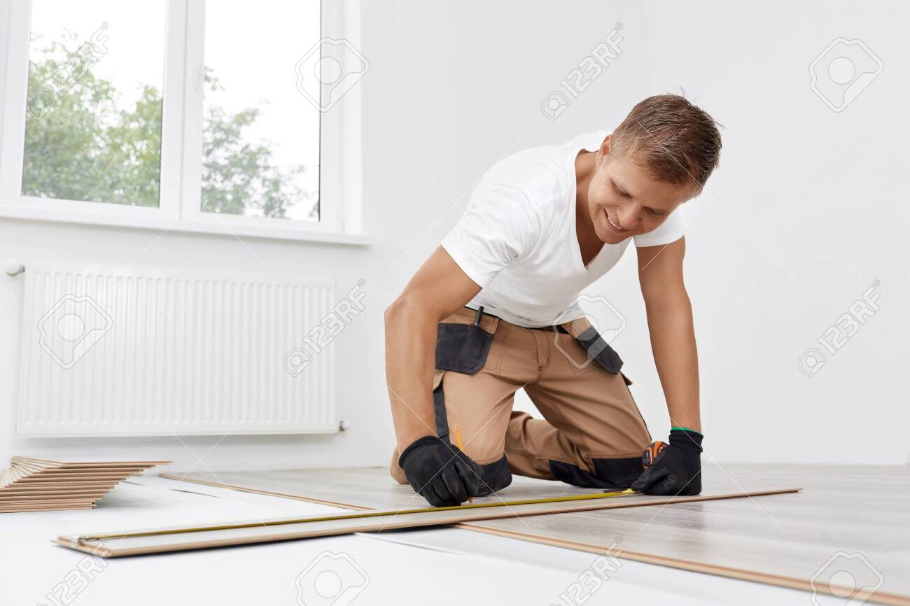 Man installing new wooden laminate flooring - 143965654 Man installing new wooden laminate flooring - 143965654