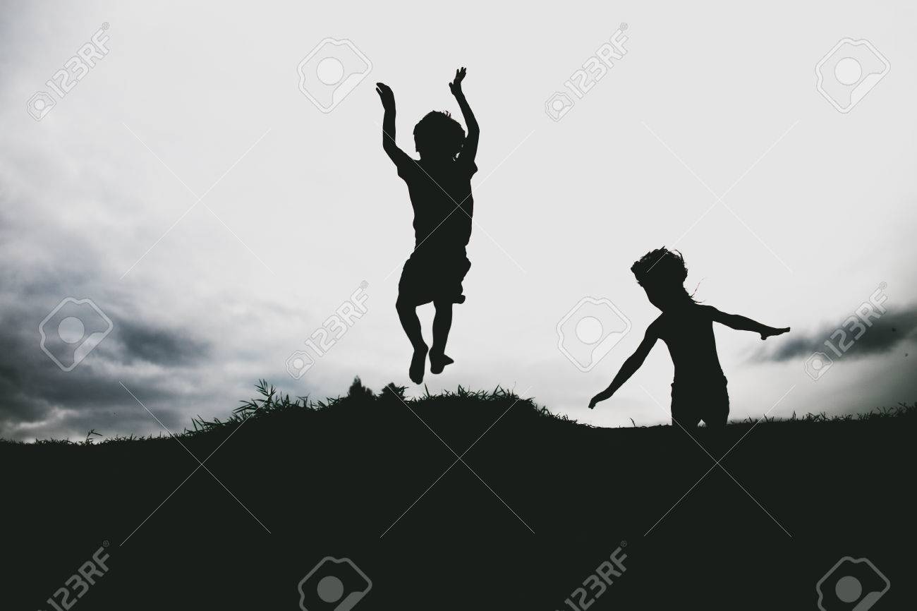 ビーチで砂の崖からジャンプする子供たちのシルエット の写真素材 画像素材 Image