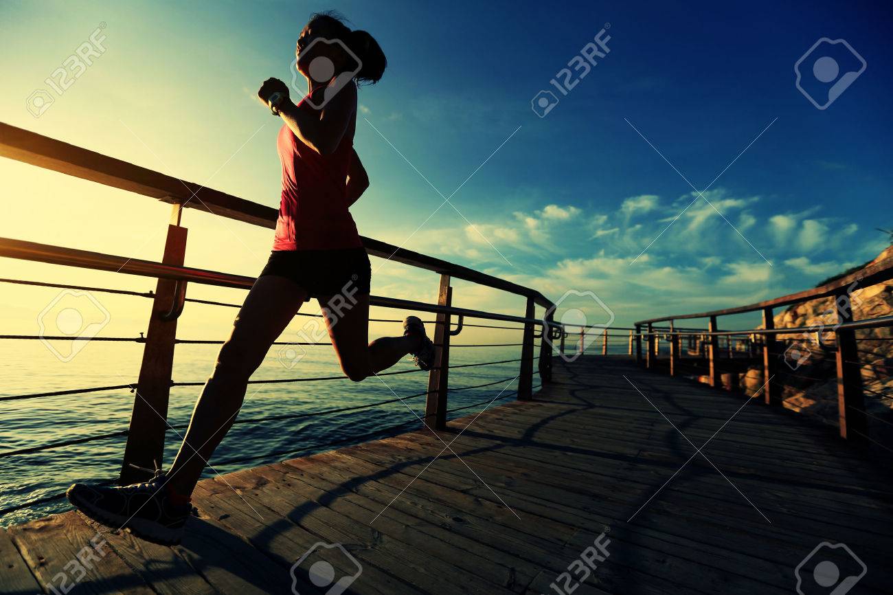 healthy lifestyle sports woman running on wooden boardwalk sunrise seaside - 50148788 healthy lifestyle sports woman running on wooden boardwalk sunrise seaside - 50148788