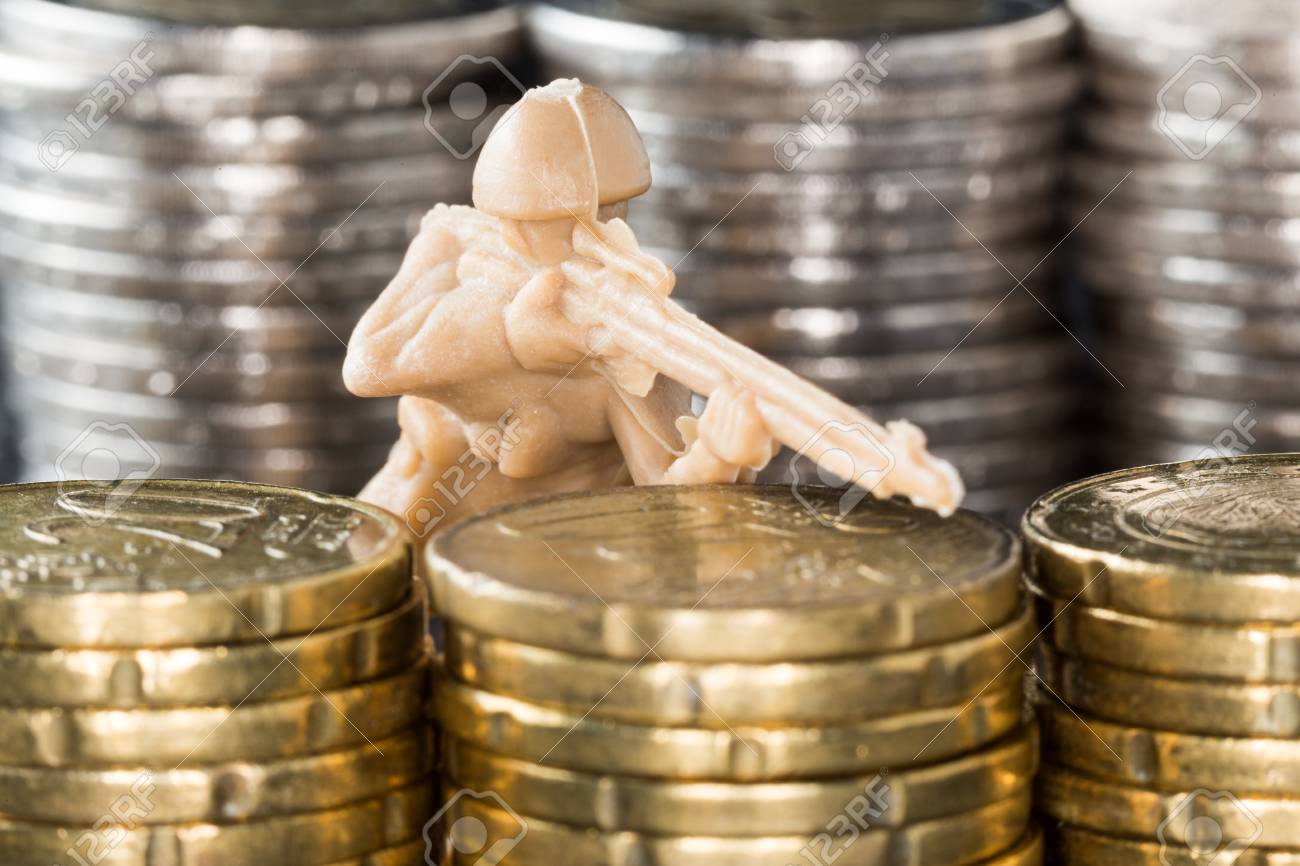 硬貨 守るお金の概念または防御的な投資のスタックの間におもちゃの兵隊 の写真素材 画像素材 Image