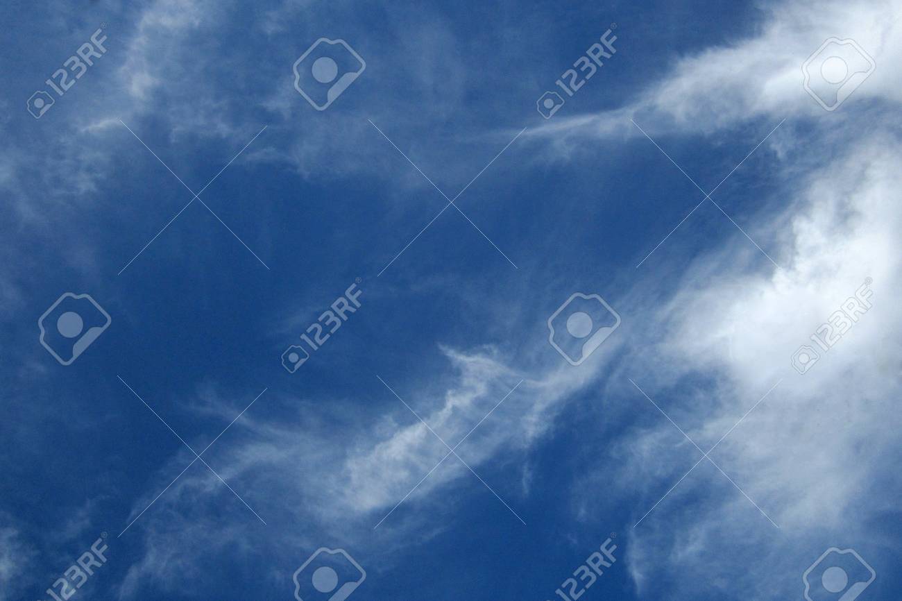 wispy jet vapor trails mingle with cirrus clouds in a deep blue vapor trails