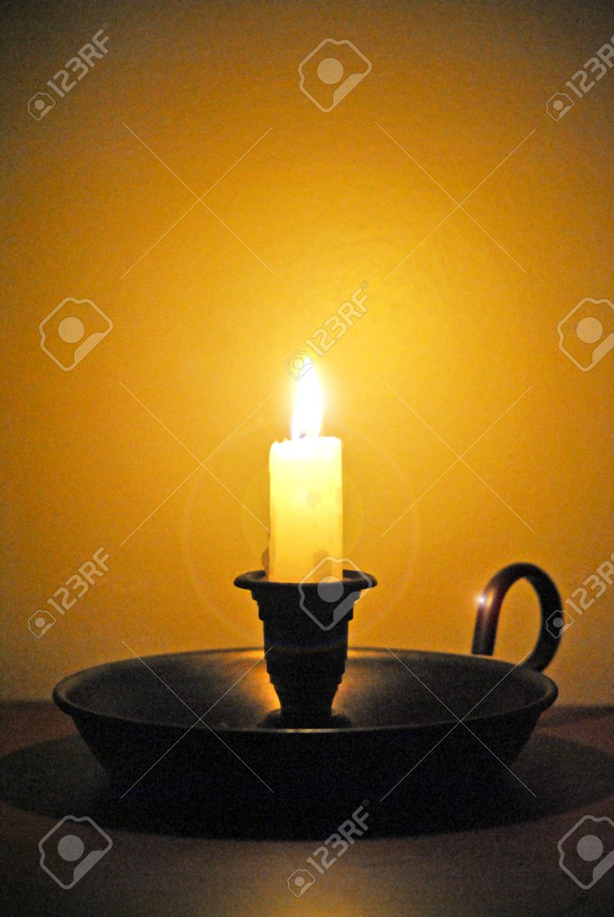 white candle in an old fashioned candlestick holder stock photo