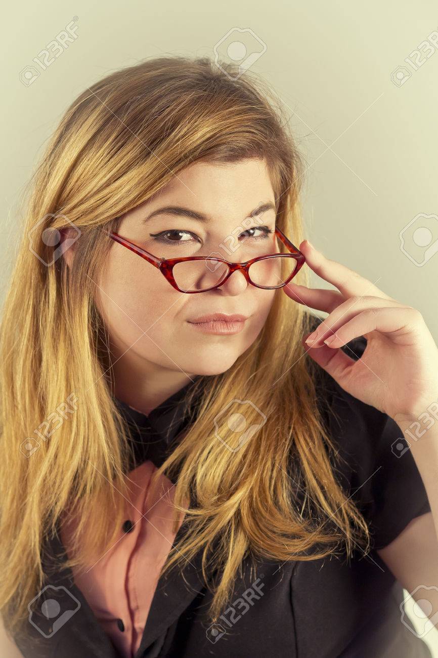 cute nerdy girl with reading glasses posing for a portrait stock