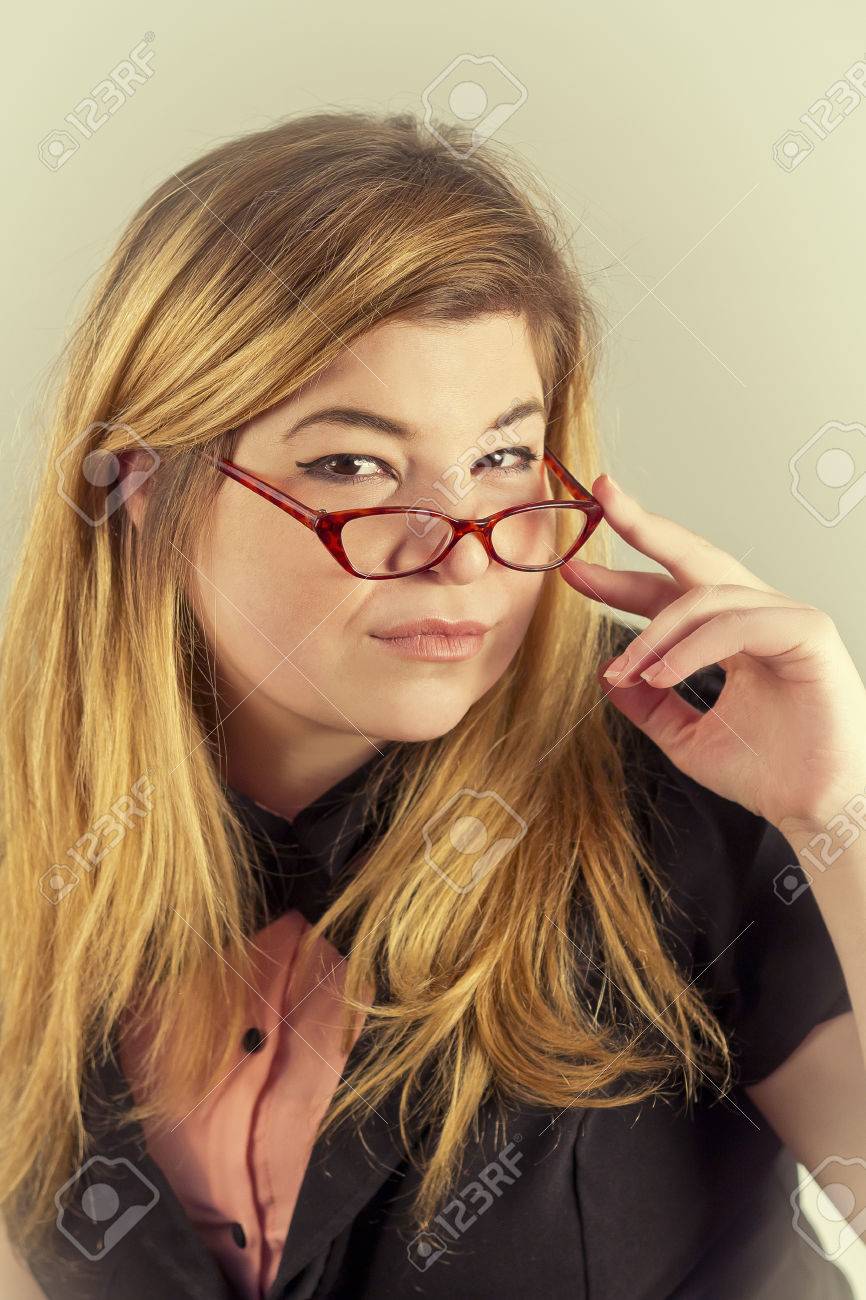 cute nerdy girl with reading glasses posing for a portrait