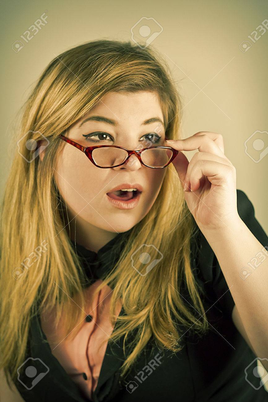 cute nerdy girl with reading glasses posing for a portrait stock