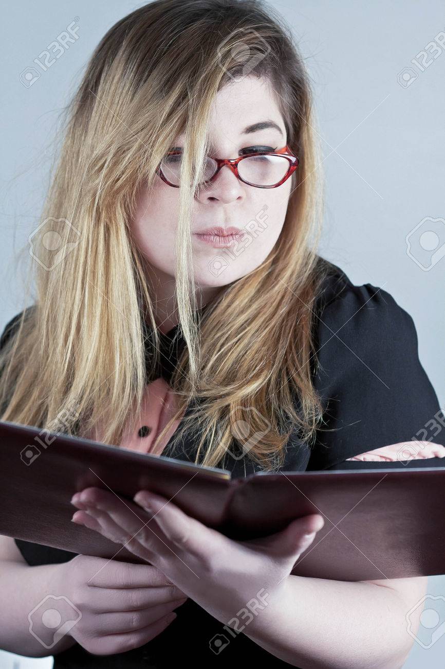 cute nerdy girl with reading glasses posing for a portrait stock