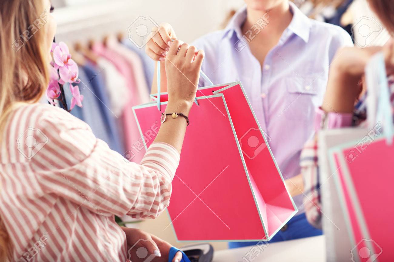 Closeup mid section of female customer receiving shopping bags in boutique - 73326293 Closeup mid section of female customer receiving shopping bags in boutique - 73326293