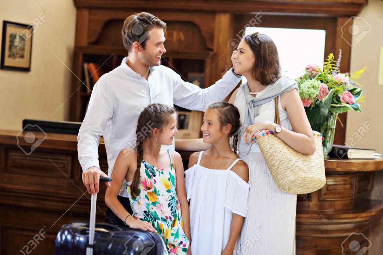 https://previews.123rf.com/images/macniak/macniak1808/macniak180800078/106214821-happy-family-checking-in-hotel-at-reception-desk.jpg