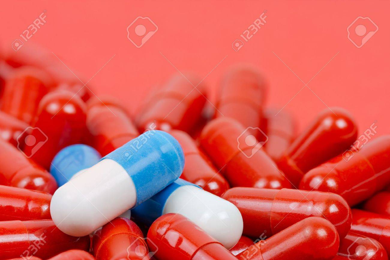 Blue and white pills on background of red pills - 20556353 Blue and white pills on background of red pills - 20556353