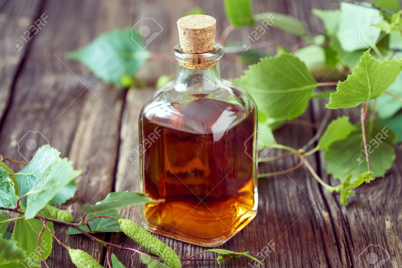 A transparent bottle of homemade herbal tincture with fresh birch branches - 169337991 A transparent bottle of homemade herbal tincture with fresh birch branches - 169337991
