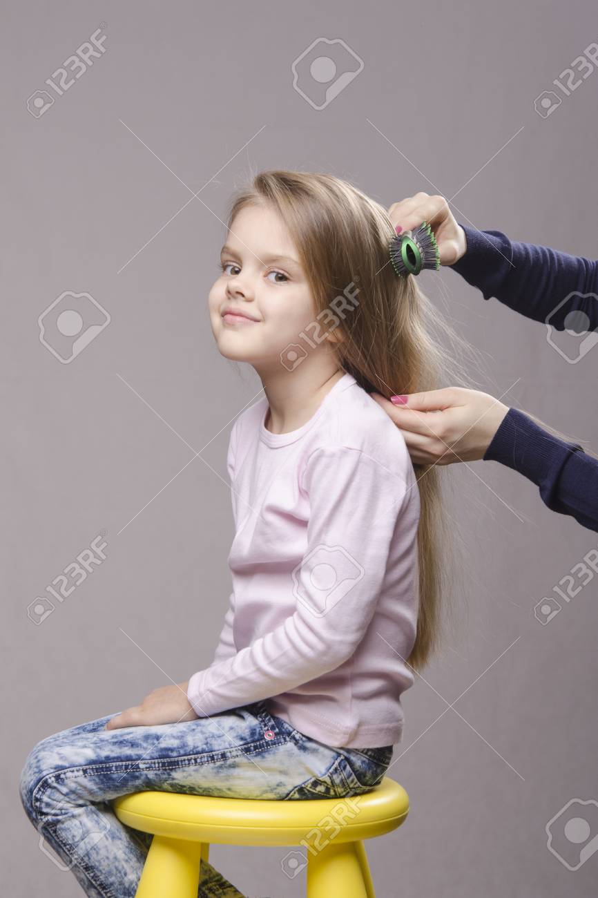 彼女の長い髪の 5 歳の女の子をブラッシング美容院 の写真素材 画像素材 Image