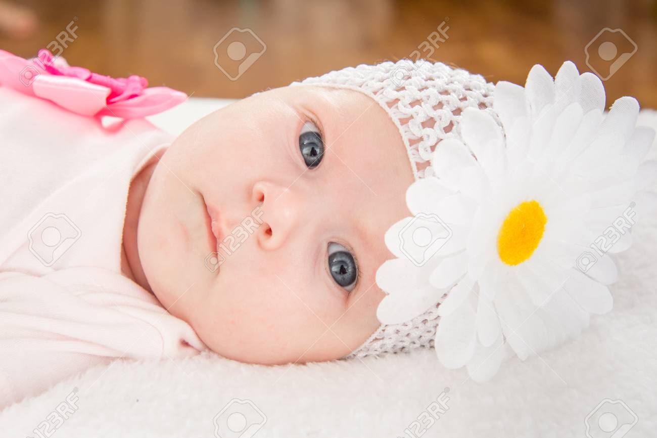 花の柔らかいベッドで横になっている彼の頭に包帯で背中に 2 ヶ月の赤ちゃん女の子ヨーロッパ の写真素材 画像素材 Image